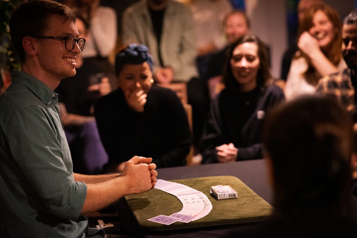 Sam King performing stunning close-up card magic for a captivated audience member at Adelaide Magic Theatre